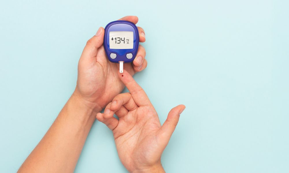  Meranie hladiny cukru v krvi glukomerom v domácom prostredí, kvapka krvi na prste a digitálny displej ukazujú hodnotu glykémie ako súčasť prevencie ochorení a pravidelnej samokontroly zdravia.