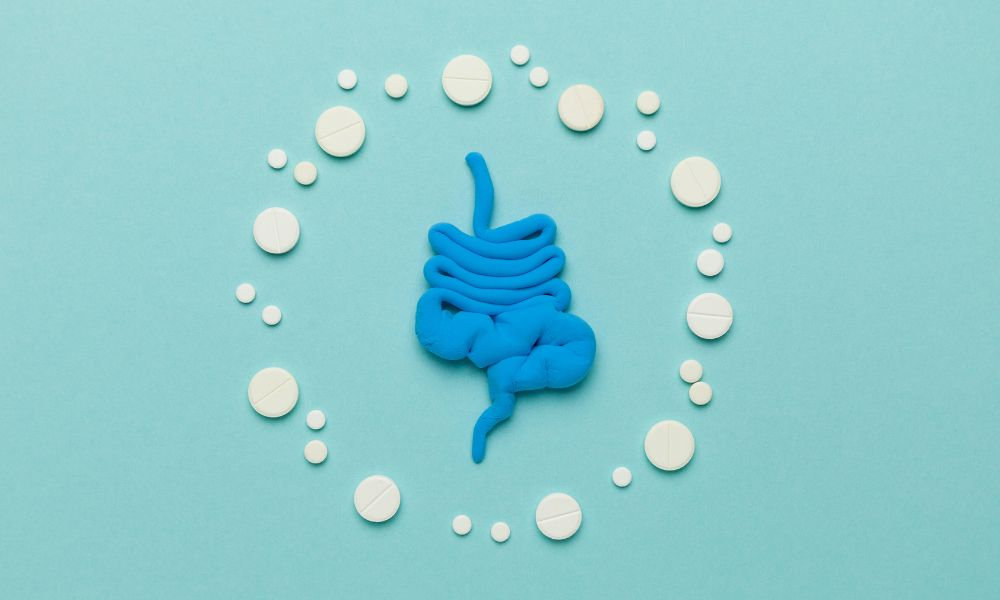  Ilustrácia čriev obklopená tabletami znázorňuje chronickú zápchu, spomalené trávenie a potrebu cielenej liečby zápchy pomocou úpravy stravy, vlákniny a vhodných doplnkov.