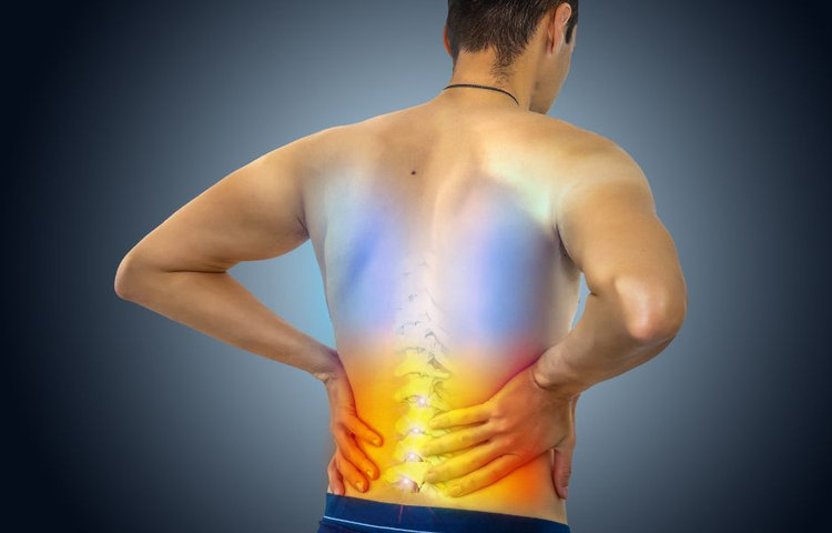 Muž si drží driekovú časť chrbtice so zvýraznenou bolesťou v oblasti krížov, čo znázorňuje akútnu bolesť chrbta, preťaženie svalov a problémy s driekovou chrbticou.