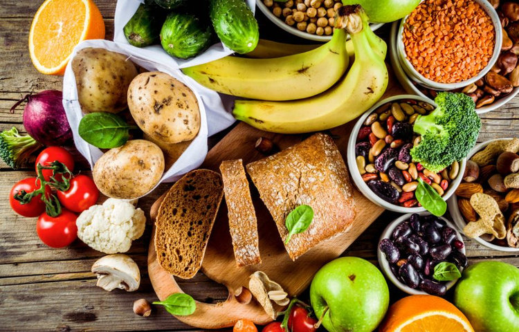 Rôzne potraviny bohaté na vlákninu vrátane ovocia, zeleniny, strukovín a celozrnného pečiva – zdroje vlákniny v jedle