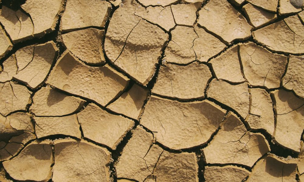  Popraskaná suchá zem symbolizuje extrémne suchú pokožku v zime, stratu vlhkosti, dehydratáciu kože a potrebu intenzívnej starostlivosti o pokožku.