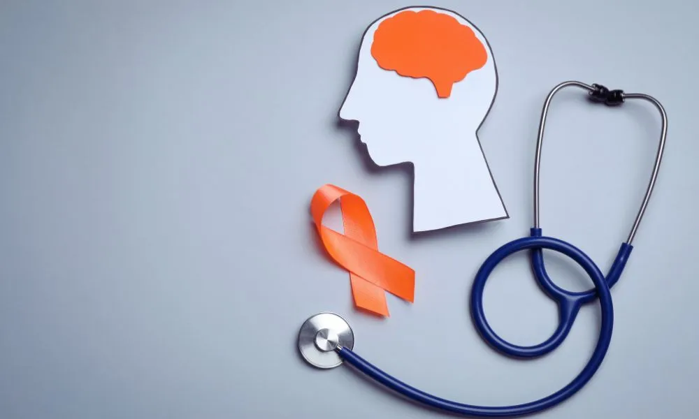 Ilustrácia mozgu s oranžovou stužkou symbolizujúcou podporu – skleróza multiplex a jej príznaky a diagnostika