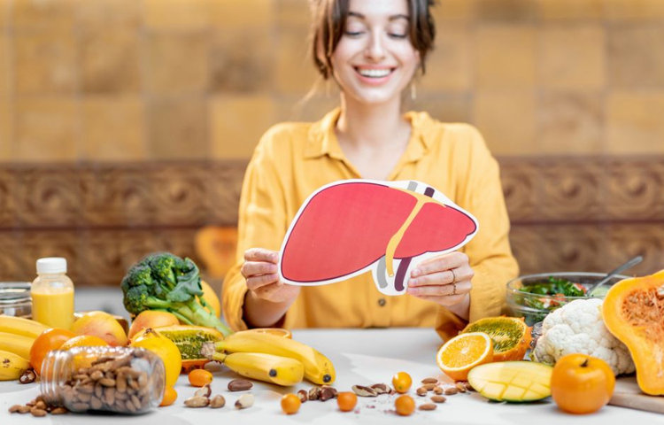 Pečeňová diéta jedálniček – žena s modelom pečene a ovocím na stole